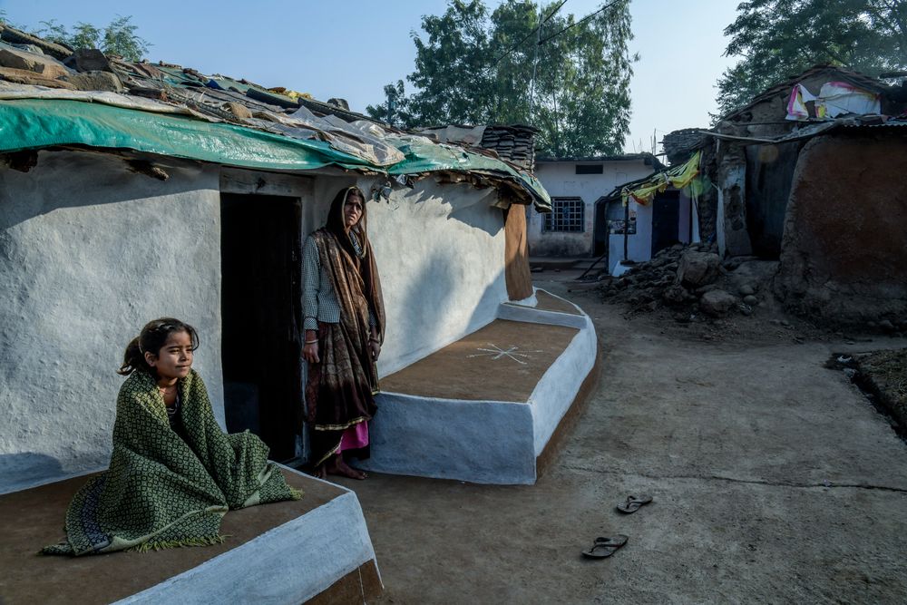 A woman seated outside her home in an Indian village